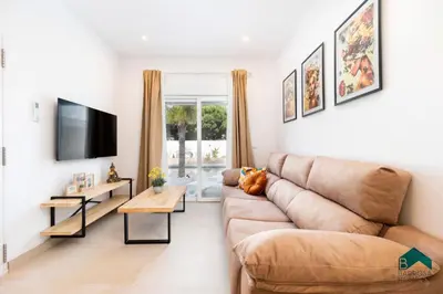 a living room with a couch and a tv at Adosados del Tio Pepe in Chiclana de la Frontera
