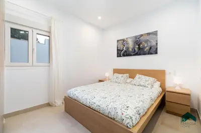 a bedroom with a bed and a picture on the wall at Adosados del Tio Pepe in Chiclana de la Frontera