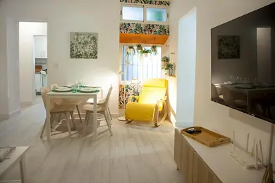 a living room with a table and a dining room at Sanlúcarsun Apartamento en el centro in Sanlúcar de Barrameda
