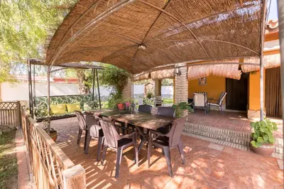 an outdoor patio with a wooden table and chairs at La Redondela in Chiclana de la Frontera