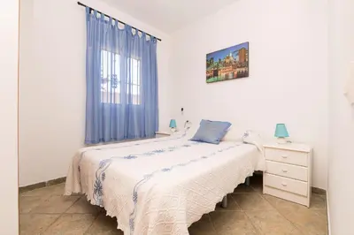 a white bedroom with a bed and a window at La Redondela in Chiclana de la Frontera