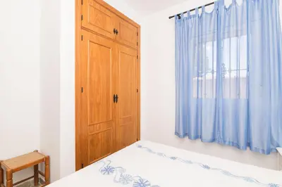 a bedroom with a bed and a wooden door at La Redondela in Chiclana de la Frontera