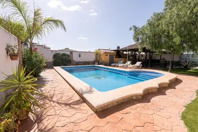 a swimming pool in a yard with a patio at La Redondela in Chiclana de la Frontera