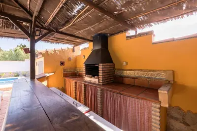 an outdoor kitchen with a fireplace in a house at La Redondela in Chiclana de la Frontera