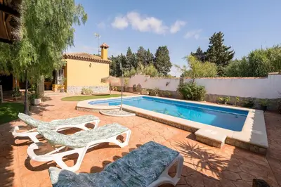 a swimming pool with two lounge chairs and a swimming pool at La Redondela in Chiclana de la Frontera