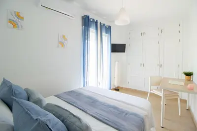 a bedroom with a bed and a table and a desk at El paraíso de los Suᴇños in Chiclana de la Frontera