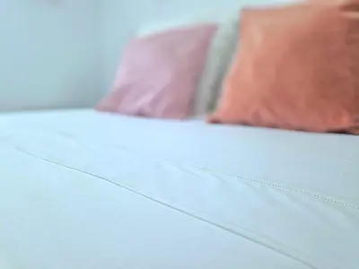 a close up of a white bed with pink pillows at El paraíso de los Suᴇños in Chiclana de la Frontera