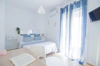 a white room with a bed and a table at El paraíso de los Suᴇños in Chiclana de la Frontera
