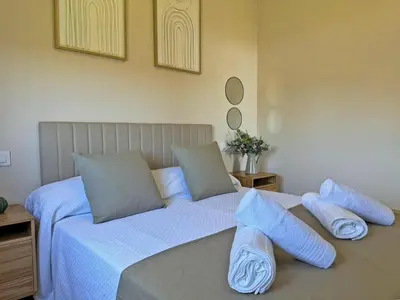a bed with blue pillows on top of it at Casa Las Mironas I - Ole Solutions in El Puerto de Santa María