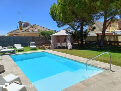 a swimming pool in a yard with a gazebo at Chalet vacacional in El Puerto de Santa María