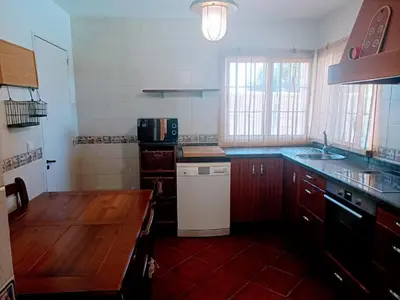 a kitchen with wooden cabinets and a counter top at Chalet vacacional in El Puerto de Santa María