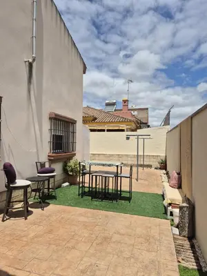 a patio with a table and chairs on the grass at Chalet vacacional in El Puerto de Santa María