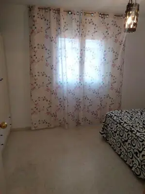 a bedroom with a bed and a window with a curtain at apartamento en Puerto Real in El Trocadero