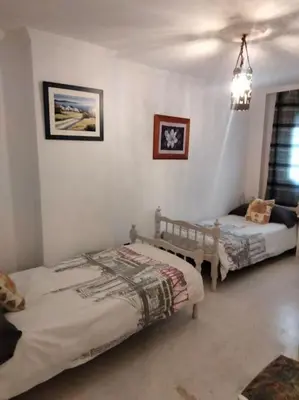 a bedroom with two beds and a chandelier at apartamento en Puerto Real in El Trocadero