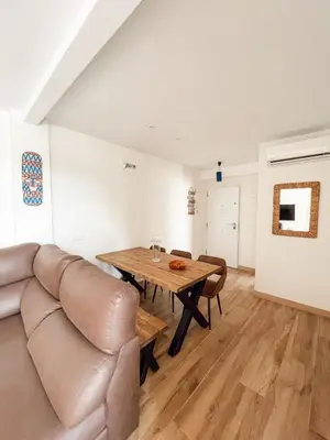 a living room with a couch and a wooden table at Apartamento Federico Deluxe con Terraza y garaje in El Puerto de Santa María