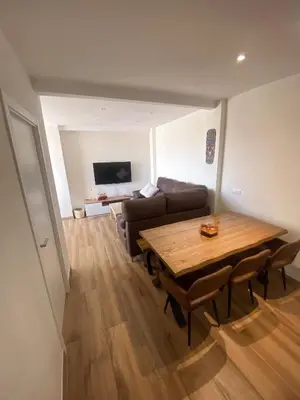 a living room with a wooden table and a couch at Apartamento Federico Deluxe con Terraza y garaje in El Puerto de Santa María