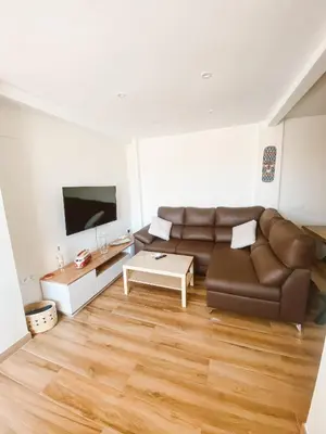 a living room with a brown couch and a table at Apartamento Federico Deluxe con Terraza y garaje in El Puerto de Santa María