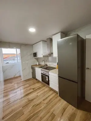 a kitchen with white cabinets and a stainless steel refrigerator at Apartamento Federico Deluxe con Terraza y garaje in El Puerto de Santa María
