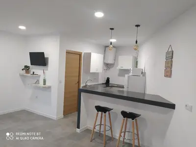 a kitchen with a counter and two bar stools at Apartamento la antigua via in Bonanza