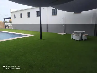 a patio with green grass next to a building at Apartamento la antigua via in Bonanza