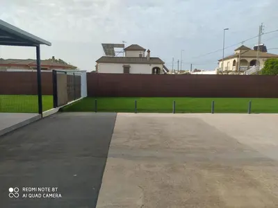 a building with a fence in front of a yard at Apartamento la antigua via in Bonanza