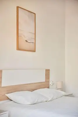 a bedroom with a white bed with a picture on the wall at El Palmeral Ha Free Parking in Cádiz
