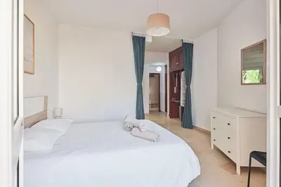 a bedroom with a white bed with two stuffed animals on it at El Palmeral Ha Free Parking in Cádiz