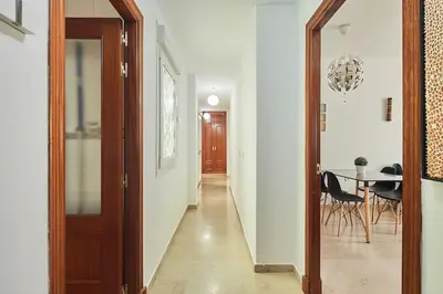 a hallway with a table and a dining room at El Palmeral Ha Free Parking in Cádiz