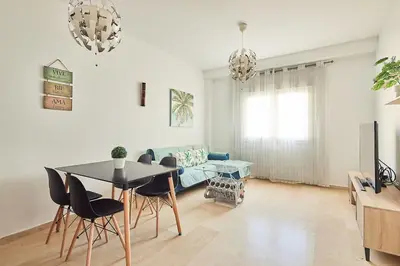 a living room with a table and chairs and a couch at El Palmeral Ha Free Parking in Cádiz