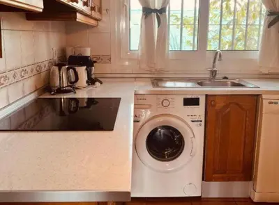 a kitchen with a washing machine and a sink at Chalet Puerto Sherry in El Puerto de Santa María