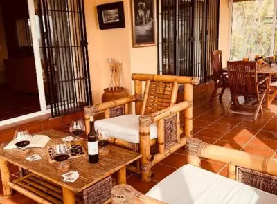 a living room with a table and chairs and windows at Chalet Puerto Sherry in El Puerto de Santa María