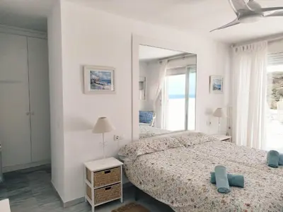 a white bedroom with two beds and a mirror at Conil Beach View Front House - Espectacular Casa con Vistas al Mar y acceso directo a la Playa in Conil de la Frontera