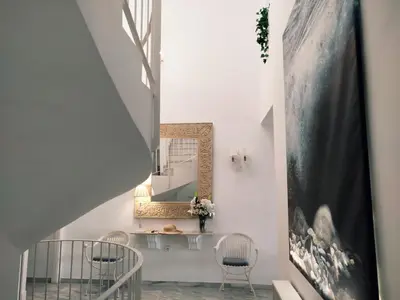 a staircase with a mirror and chairs in a room at Conil Beach View Front House - Espectacular Casa con Vistas al Mar y acceso directo a la Playa in Conil de la Frontera
