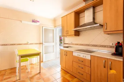 a kitchen with wooden cabinets and a yellow table at Frambuesa by Cádiz Time in Chiclana de la Frontera