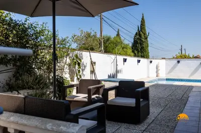 a patio with chairs and an umbrella next to a pool at Frambuesa by Cádiz Time in Chiclana de la Frontera