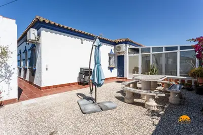 a patio with a table and an umbrella at Frambuesa by Cádiz Time in Chiclana de la Frontera