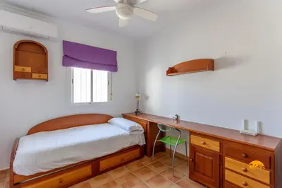 a bedroom with a bed and a desk and a window at Frambuesa by Cádiz Time in Chiclana de la Frontera