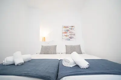 a white bed with pillows on top of it at Sibs Sanlucar Altamar Nuevo Centrico Tranquilo in Sanlúcar de Barrameda