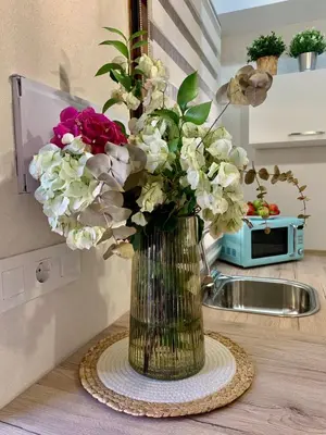 a vase filled with flowers sitting on a counter at Pimenium 318 in Medina Sidonia