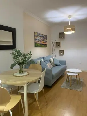 a living room with a blue couch and a table at Pimenium 318 in Medina Sidonia