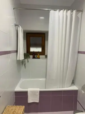 a bathroom with a bath tub with a shower curtain at Pimenium 318 in Medina Sidonia