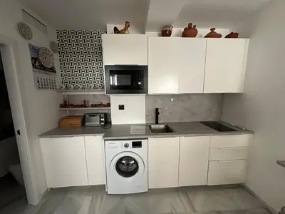 a kitchen with a washing machine and a microwave at Apartamento Condesa in Sanlúcar de Barrameda
