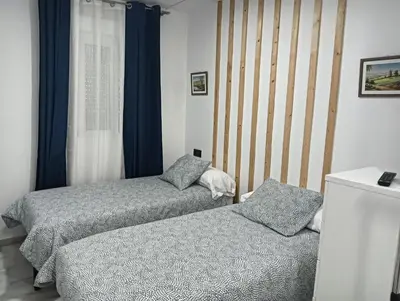 a bedroom with two beds and a window at Apartamento Condesa in Sanlúcar de Barrameda