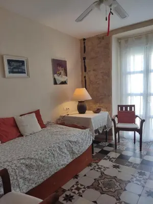 a bedroom with a bed and a table and a chair at El Brujo in Jerez de la Frontera