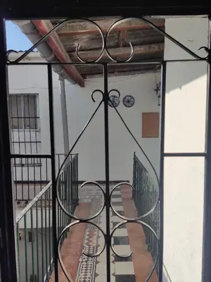 a balcony with a wrought iron railing and a staircase at El Brujo in Jerez de la Frontera