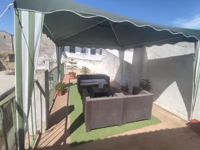 a black canopy on a balcony with a couch under it at El Brujo in Jerez de la Frontera