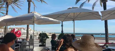 a group of people sitting at tables under umbrellas at El Brujo in Jerez de la Frontera