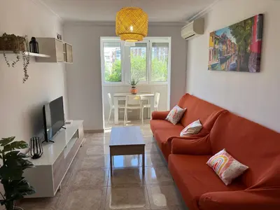 a living room with a red couch and a tv at Piso en Cadiz para Verano in Cádiz