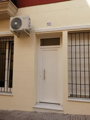 a white door on the side of a building with a fan at Apartamento María Sanlúcar con garaje in Sanlúcar de Barrameda