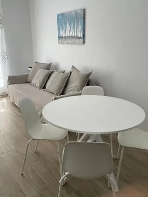 a white table and chairs in a living room with a couch at Apartamento María Sanlúcar con garaje in Sanlúcar de Barrameda